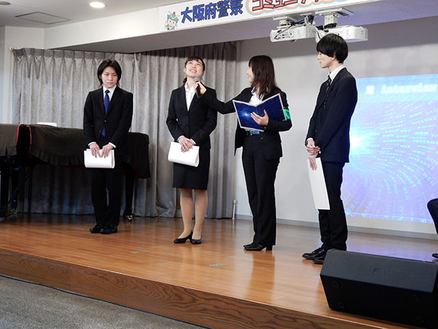 大阪府警のスタッフにインタビューをうける学生の代表。福西さん、木村さん、小山さん（左から）