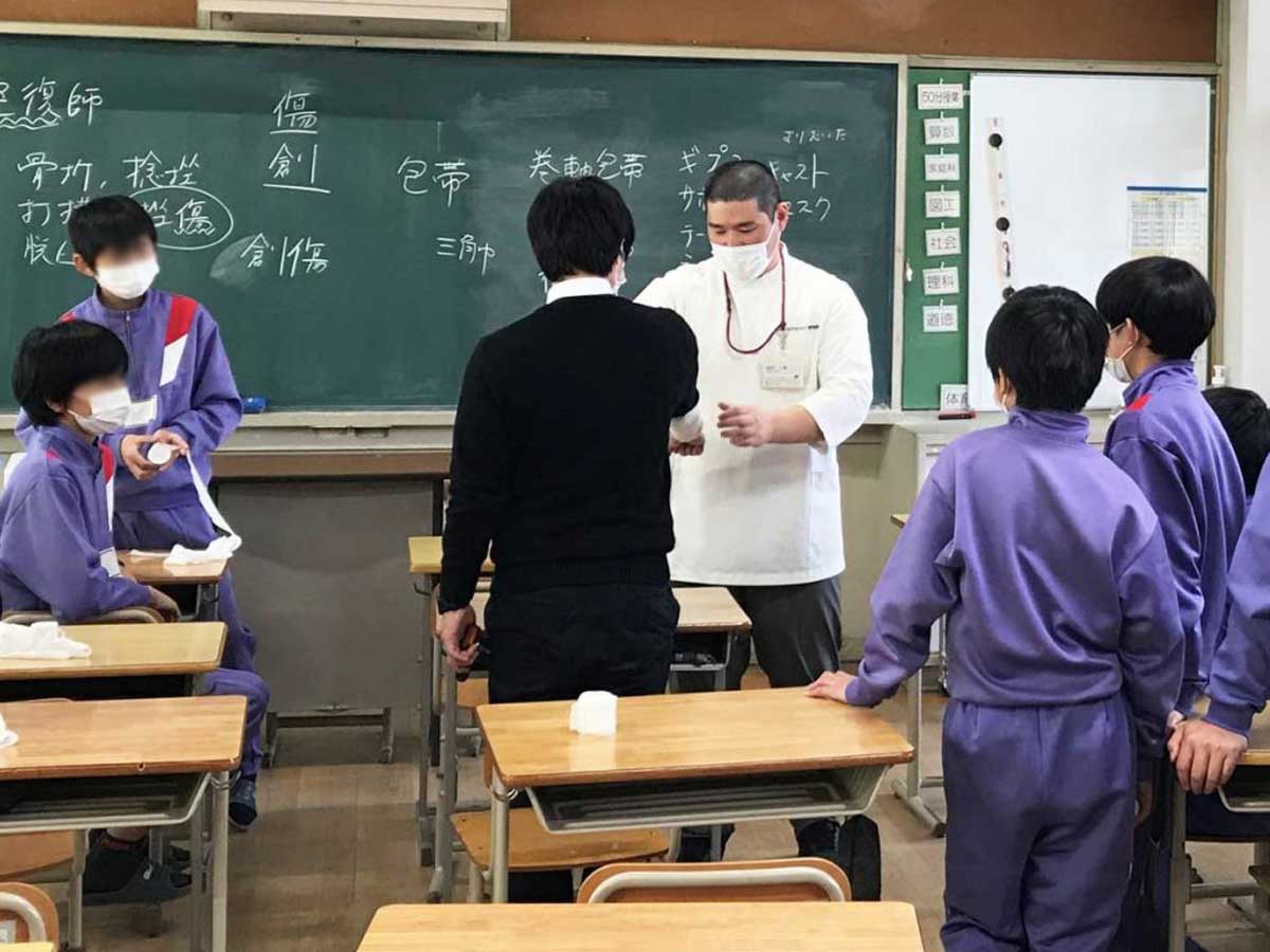 大阪ハイテクの岩村一成先生による包帯を巻く体験授業